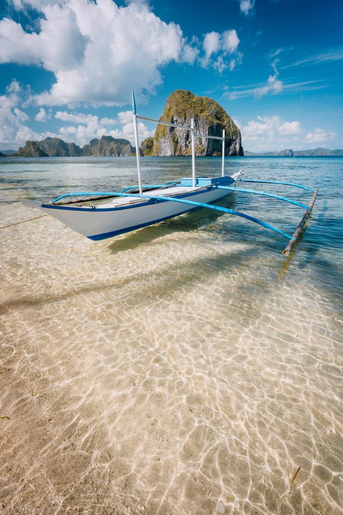 Cloudscape above picturesque lagoon with boat in El Nido, Palawan, Philippines. Unique places