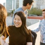 Group of asian friends talking on the street. Focus on chinese woman face